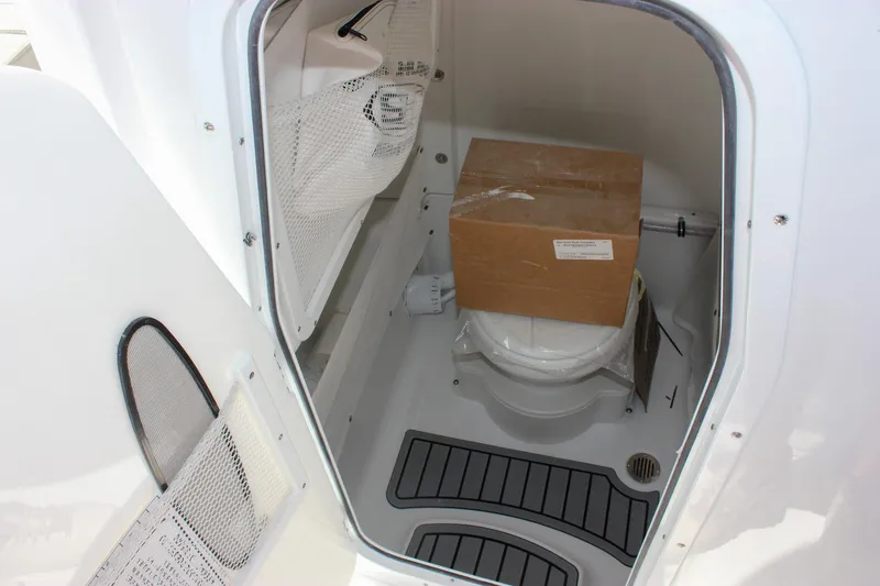 Slide: The Image of 2026 Sea Hunt Ultra 265 SE boat storage compartment with a cardboard box inside. - 15