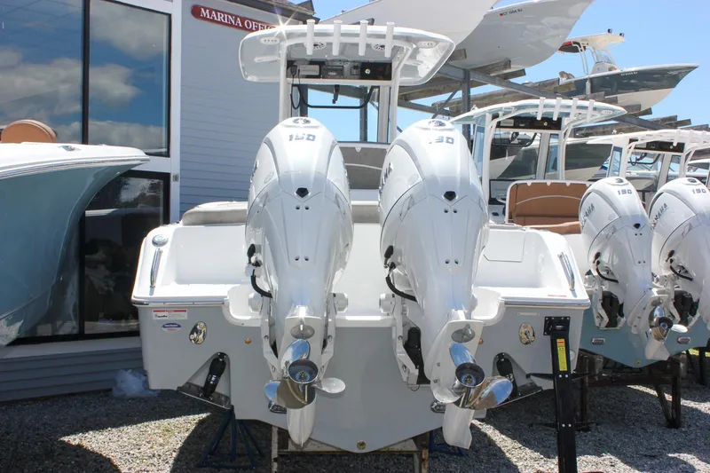 Slide: The Image of 2026 Sea Hunt Ultra 265 SE boat with dual outboard engines displayed at a marina. - 2