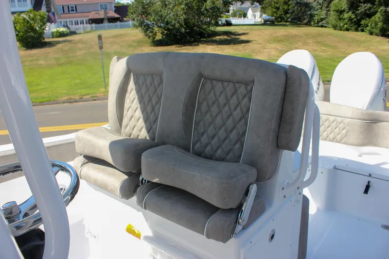 Slide: The Image of 2026 Sea Hunt Ultra 265 SE boat with plush, diamond-stitched seating in a sunny outdoor setting. - 40