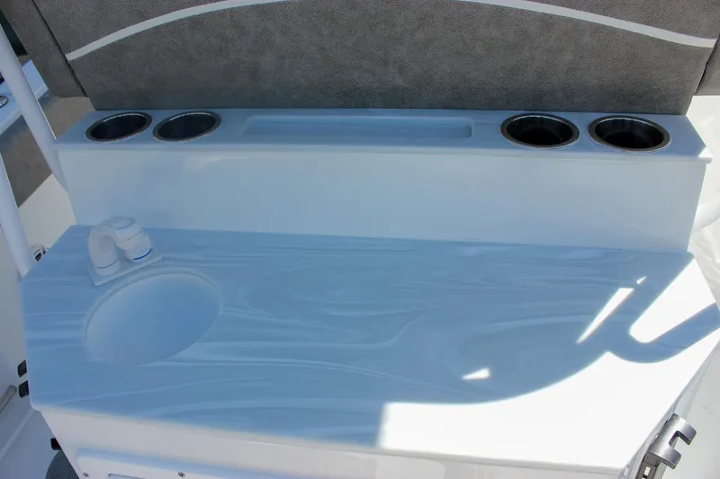 Slide: The Image of 2026 Sea Hunt Ultra 265 SE boat interior with cup holders and sink. - 41