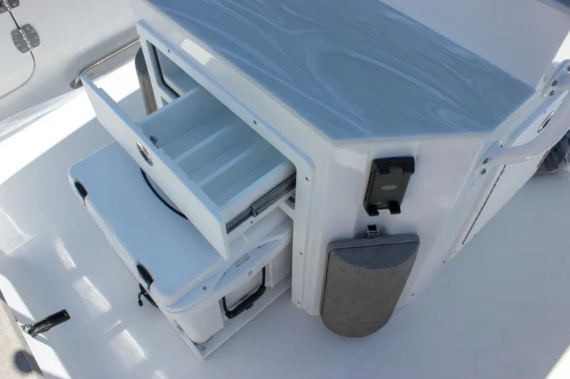 Slide: The Image of Storage compartment on 2026 Sea Hunt Ultra 265 SE boat with open drawers and cooler. - 7