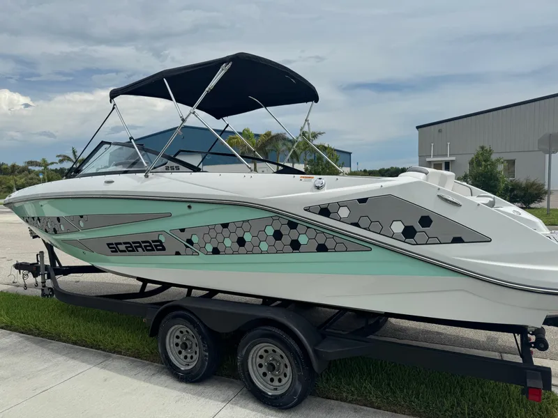 Slide: The Image of 2020 Scarab 255 Open ID boat on trailer, featuring hexagonal design and black canopy. - 18