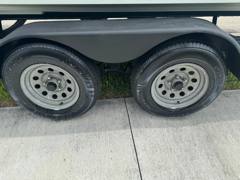 Slide: The Image of Trailer wheels of a 2020 Scarab 255 Open ID boat on pavement. - 22