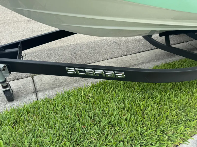 Slide: The Image of Trailer of 2020 Scarab 255 Open ID boat on grass. - 23
