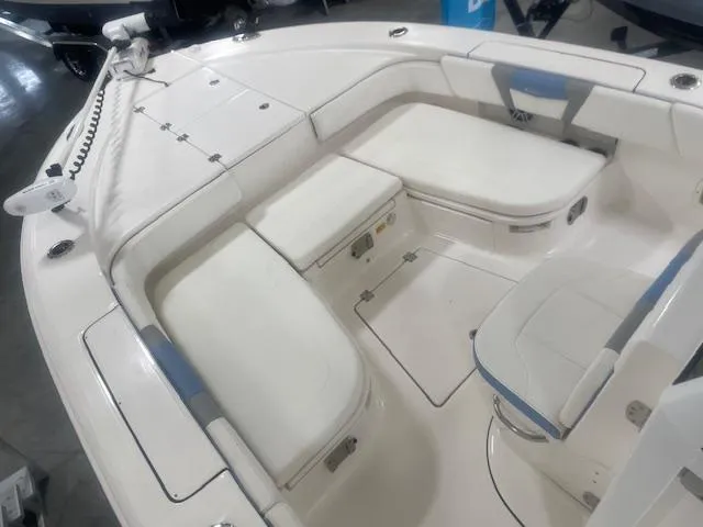 Slide: The Image of 2023 Robalo 266 Cayman boat interior with white cushioned seating and storage compartments. - 12