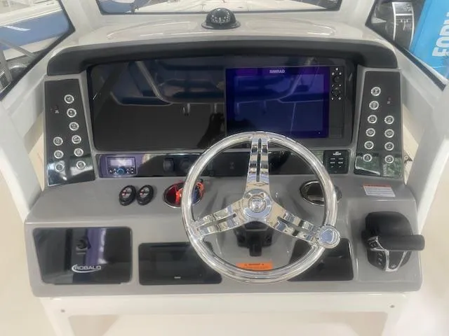 Slide: The Image of 2023 Robalo 266 Cayman boat dashboard with steering wheel and control panel. - 8
