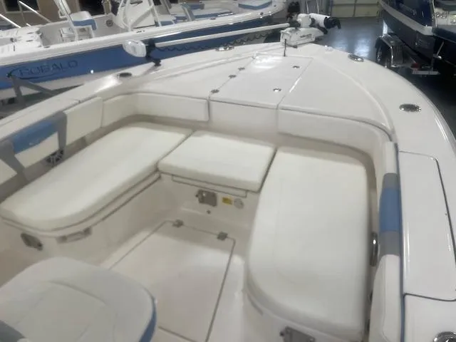 Slide: The Image of 2023 Robalo 266 Cayman boat interior with white seating and storage compartments. - 9