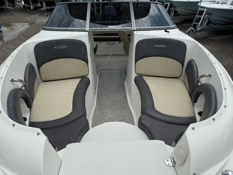 Slide: The Image of 2018 Stingray 214 LR boat interior with cushioned seating and sleek design. - 12