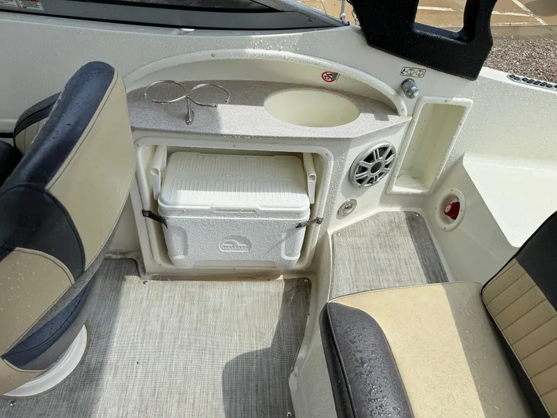 Slide: The Image of 2018 Stingray 214 LR boat interior with seating, sink, and cooler storage. - 18