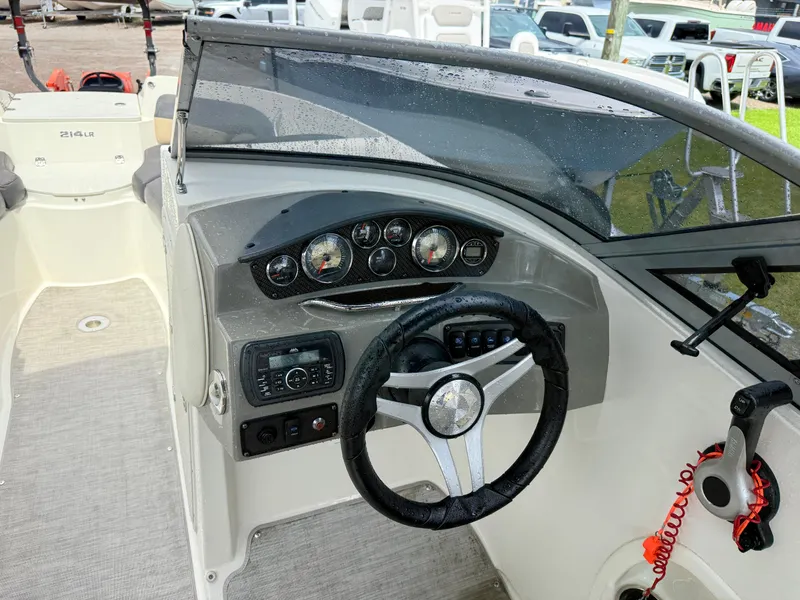 Slide: The Image of 2018 Stingray 214 LR boat dashboard with steering wheel and control panel. - 19