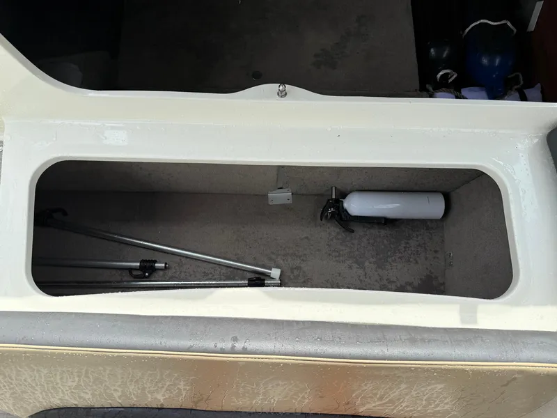 Slide: The Image of Storage compartment of a 2018 Stingray 214 LR boat with equipment and fire extinguisher. - 21