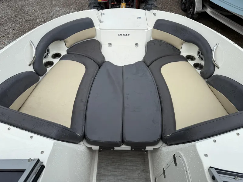 Slide: The Image of 2018 Stingray 214 LR boat interior with cushioned seating and cup holders. - 23