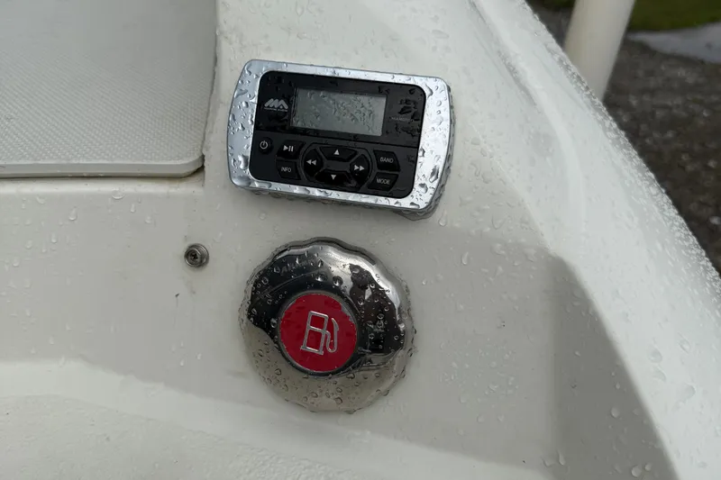 Slide: The Image of Control panel and fuel cap on a 2018 Stingray 214 LR boat, wet with raindrops. - 24
