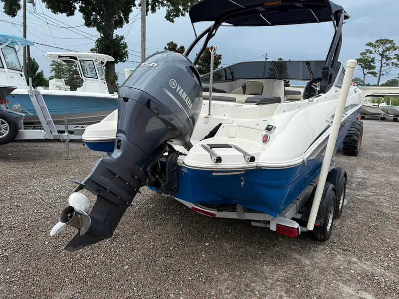Slide: The Image of 2018 Stingray 214 LR boat with Yamaha outboard motor, parked on gravel lot. - 6