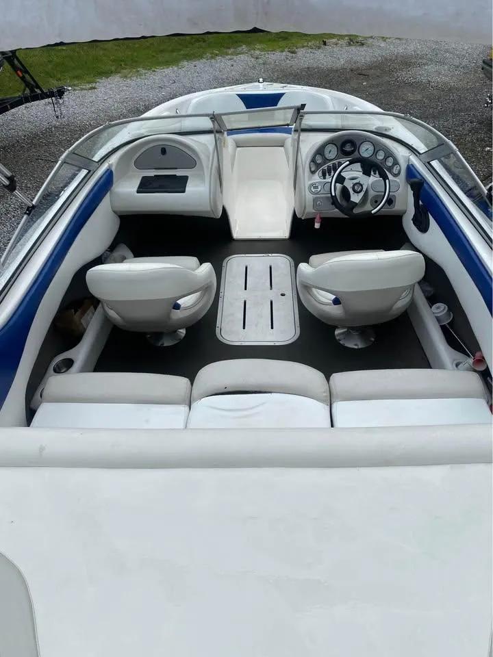 Slide: The Image of Interior of a 2005 Mariah SX19 boat with white seating and dashboard. - 5