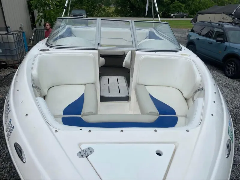 Slide: The Image of 2005 Mariah SX19 boat with white and blue seating, parked outdoors. - 7