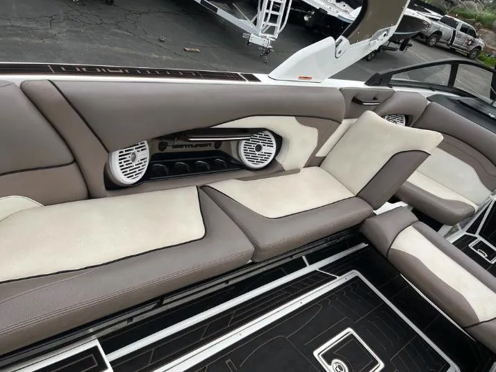 Slide: The Image of 2019 Centurion RI 257 boat interior with beige and brown seating, featuring built-in speakers. - 10