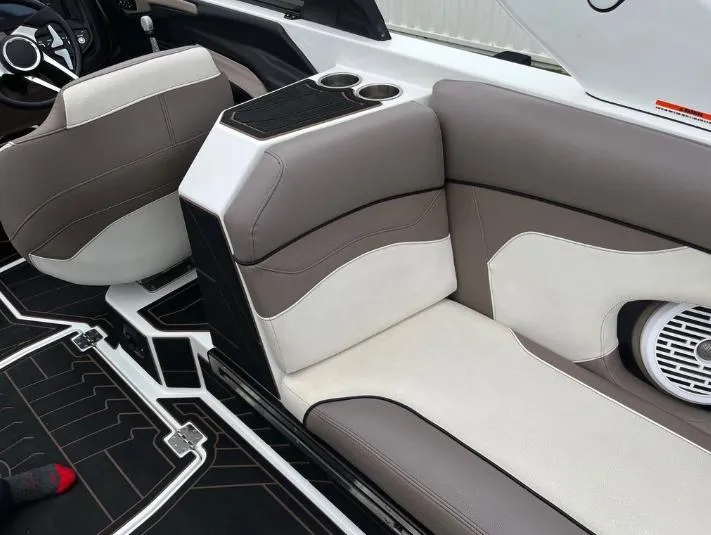 Slide: The Image of 2019 Centurion RI 257 boat interior with beige and white seating, cup holders, and speaker. - 16