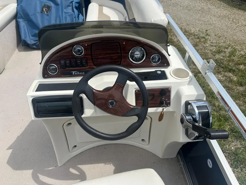Slide: The Image of Steering console of 2011 Tahoe LT1900 boat with wood accents and controls. - 8