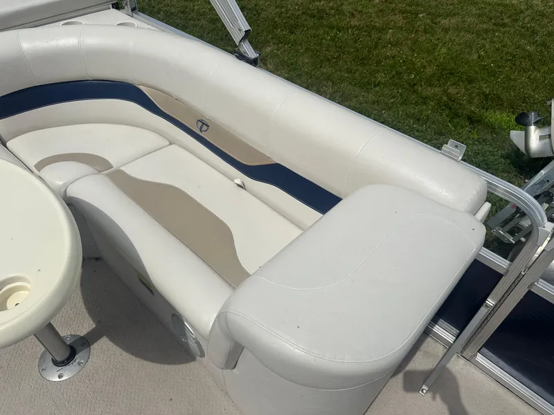 Slide: The Image of White and beige seating on a 2011 Tahoe LT1900 boat, with a small table nearby. - 9