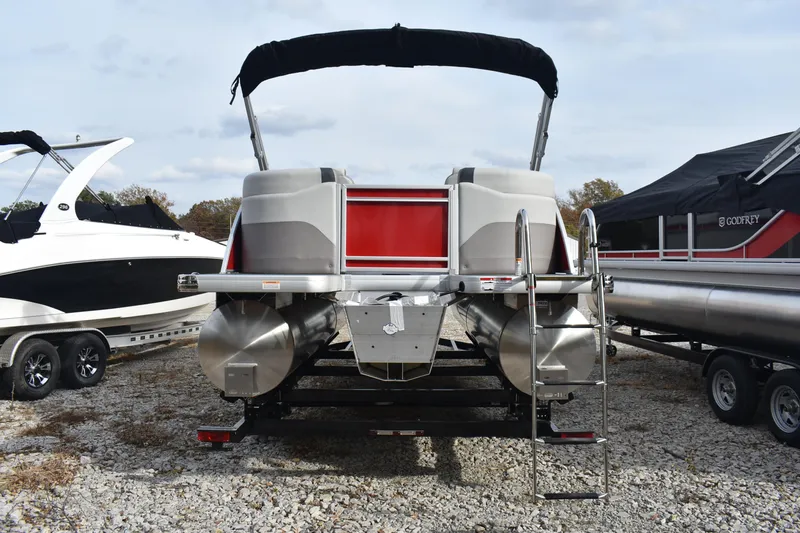 Slide: The Image of 2025 Godfrey Sweetwater 2086 SB pontoon boat, rear view, parked on gravel. - 3