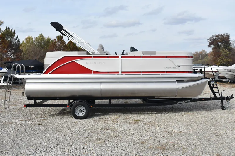 Slide: The Image of 2025 Godfrey Sweetwater 2086 SB pontoon boat on trailer, parked on gravel lot. - 6