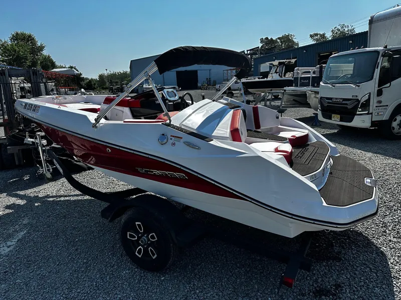 Slide: The Image of 2023 Scarab 165ID Jet Boat with red and white design on a trailer. - 2