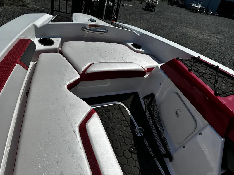 Slide: The Image of 2023 Scarab 165ID Jet Boat interior with red and white seating, cup holders, and storage. - 6