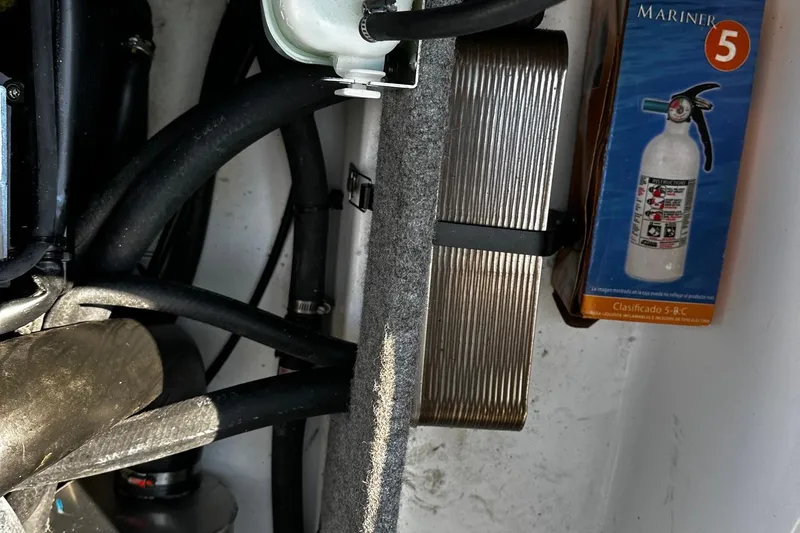 Slide: The Image of Engine compartment of 2023 Scarab 165ID Jet Boat with fire extinguisher and hoses. - 8