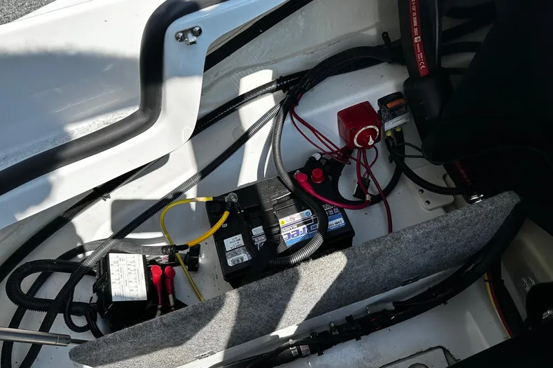 Slide: The Image of 2023 Scarab 165ID Jet Boat engine compartment with battery and wiring. - 9