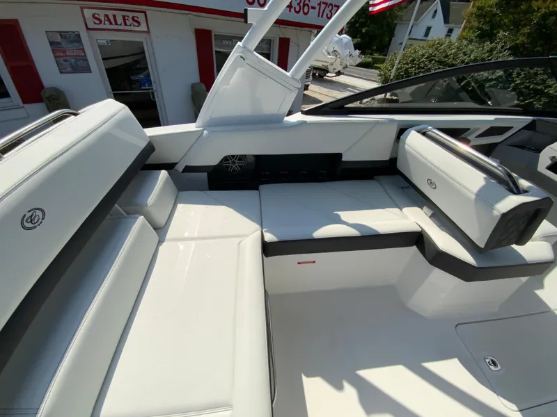 Slide: The Image of 2026 Cobalt R4 OB boat interior with white seating, displayed at a sales location. - 18
