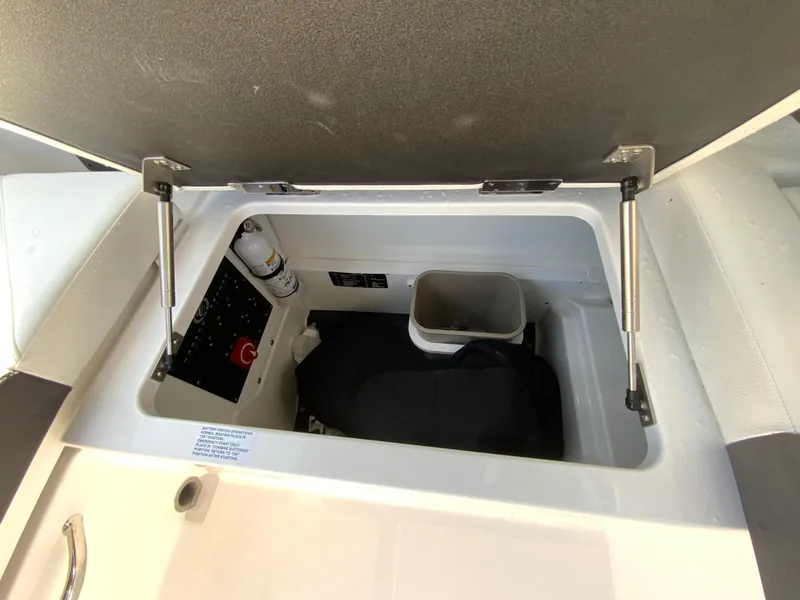 Slide: The Image of Open storage compartment in 2026 Cobalt R4 OB boat, featuring safety equipment and organized space. - 19
