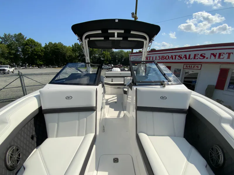 Slide: The Image of 2026 Cobalt R4 OB boat interior with white seating and black canopy under a sunny sky. - 28