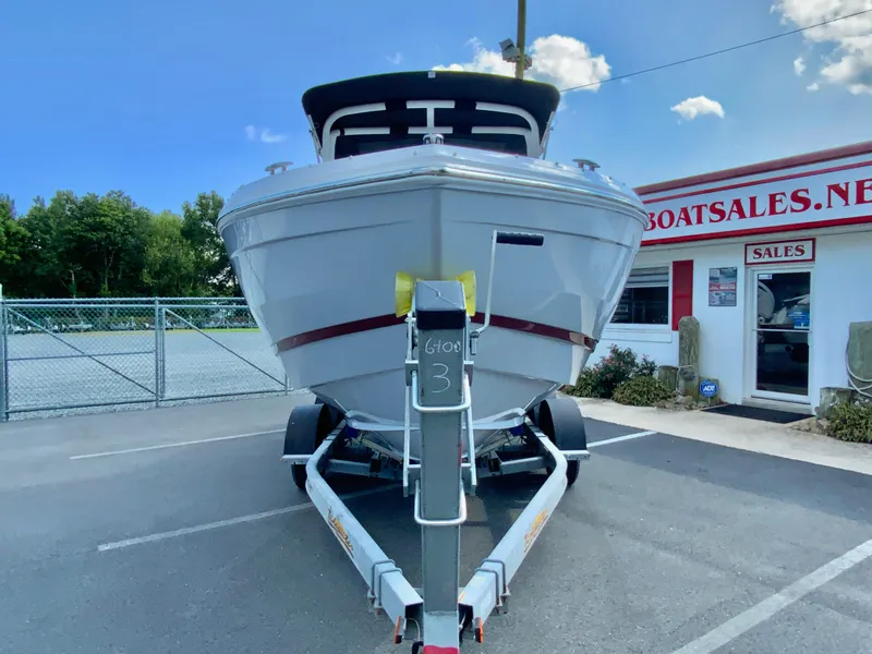 Slide: The Image of 2026 Cobalt R4 OB boat on trailer at dealership, clear sky background. - 4