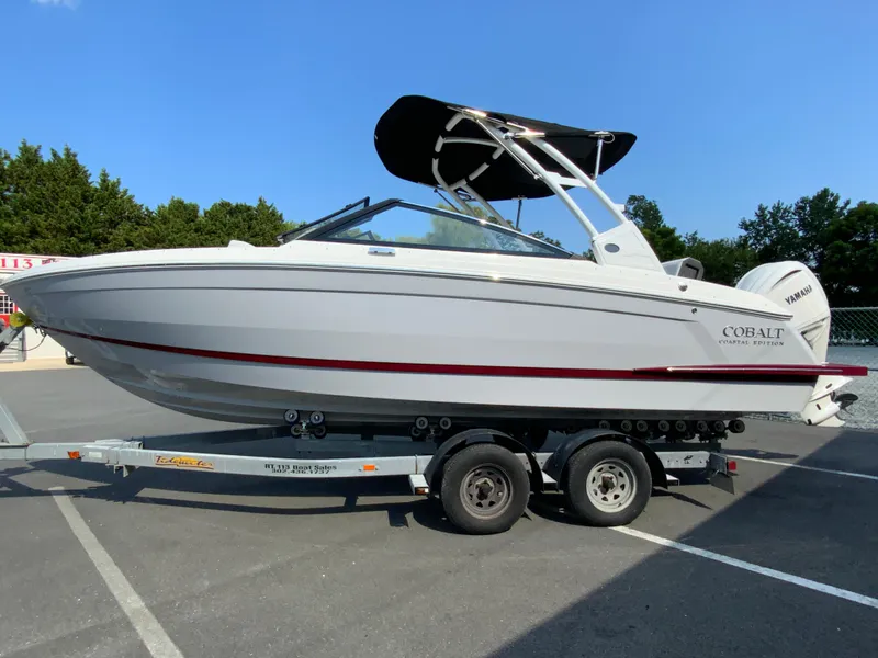 Slide: The Image of 2026 Cobalt R4 OB boat on trailer, white with red stripe, parked outdoors. - 6