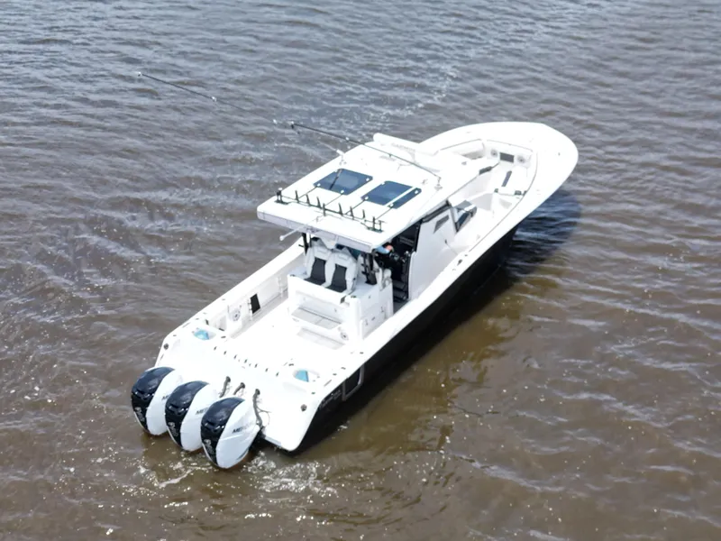 Slide: The Image of 2023 Tidewater 380 CC Adventure boat docked under a cloudy sky. - 11
