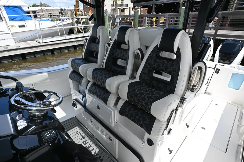 Slide: The Image of 2023 Tidewater 380 CC Adventure boat docked, featuring a covered console and sleek design. - 16