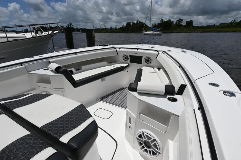 Slide: The Image of 2023 Tidewater 380 CC Adventure boat interior with seating and speakers on a calm waterway. - 5