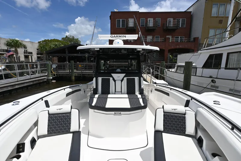 Slide: The Image of 2023 Tidewater 380 CC Adventure boat docked, featuring spacious seating and modern design. - 6
