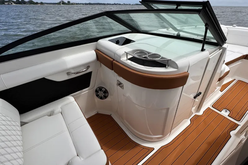 Slide: The Image of 2024 Sea Ray SDX 270 Outboard interior with white seating and wood accents. - 10