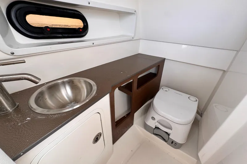 Slide: The Image of 2024 Sea Ray SDX 270 Outboard interior with sink and portable toilet. - 11