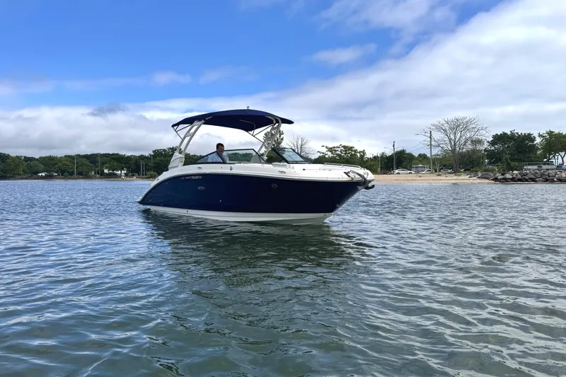 Slide: The Image of 2024 Sea Ray SDX 270 Outboard boat on calm water, clear sky background. - 2