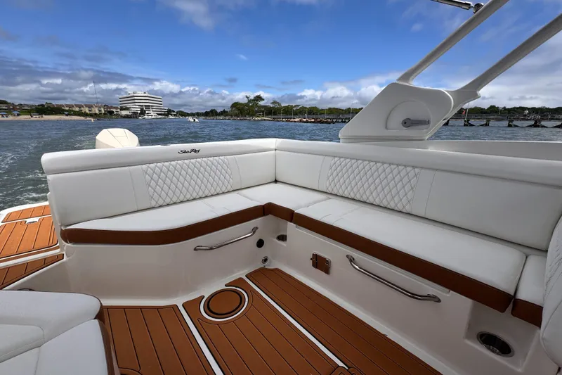 Slide: The Image of 2024 Sea Ray SDX 270 Outboard boat interior with white seating and wooden deck. - 3