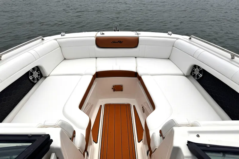 Slide: The Image of 2024 Sea Ray SDX 270 Outboard boat interior with white seating and wood accents. - 5