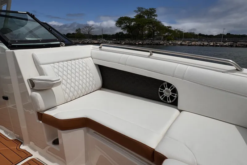 Slide: The Image of 2024 Sea Ray SDX 270 Outboard interior with white leather seating and speaker. - 6