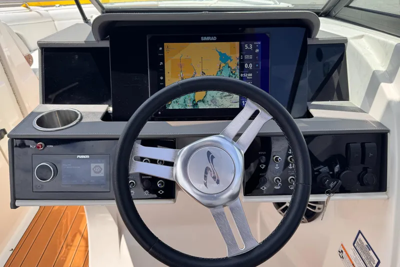 Slide: The Image of 2024 Sea Ray SDX 270 Outboard dashboard with steering wheel and navigation display. - 7
