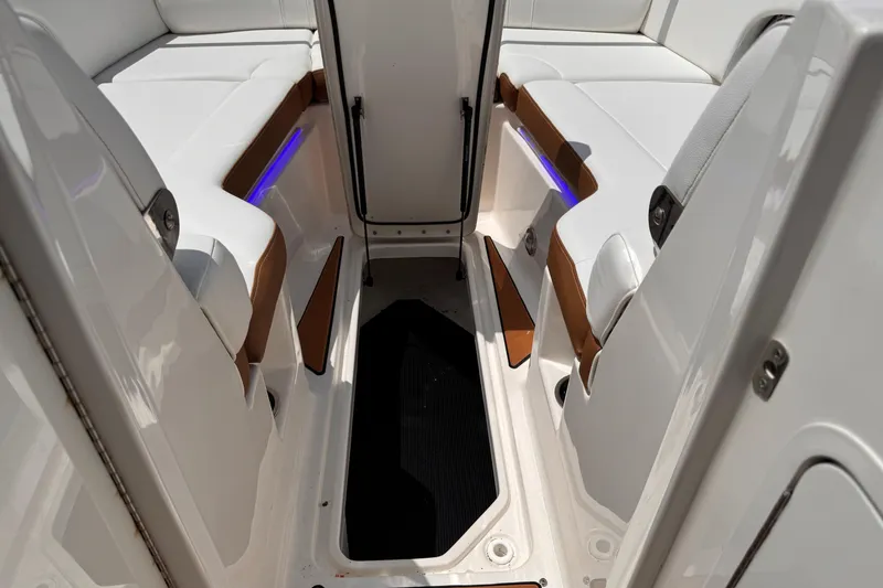 Slide: The Image of 2024 Sea Ray SDX 270 Outboard interior with white seating and ambient blue lighting. - 8