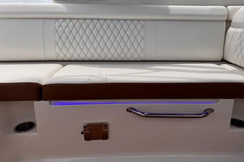 Slide: The Image of 2024 Sea Ray SDX 270 Outboard boat seating with white upholstery and blue LED lighting. - 9