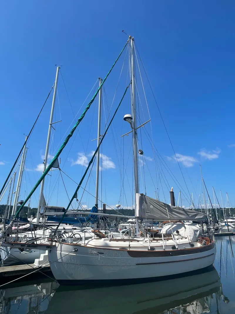 Slide: The Image of 1985 Hans Christian 33T sailboat docked in a marina under clear blue skies. - 1