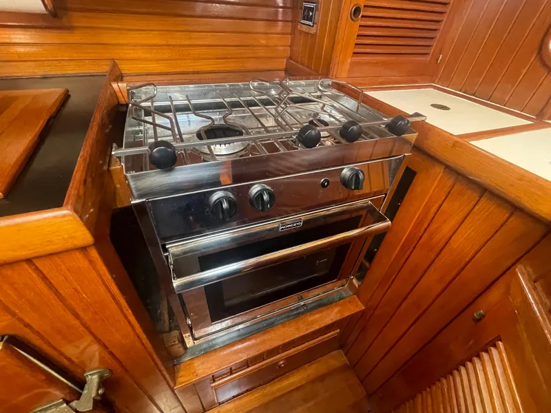 Slide: The Image of Stainless steel stove in 1985 Hans Christian 33T yacht galley, surrounded by rich wood paneling. - 15